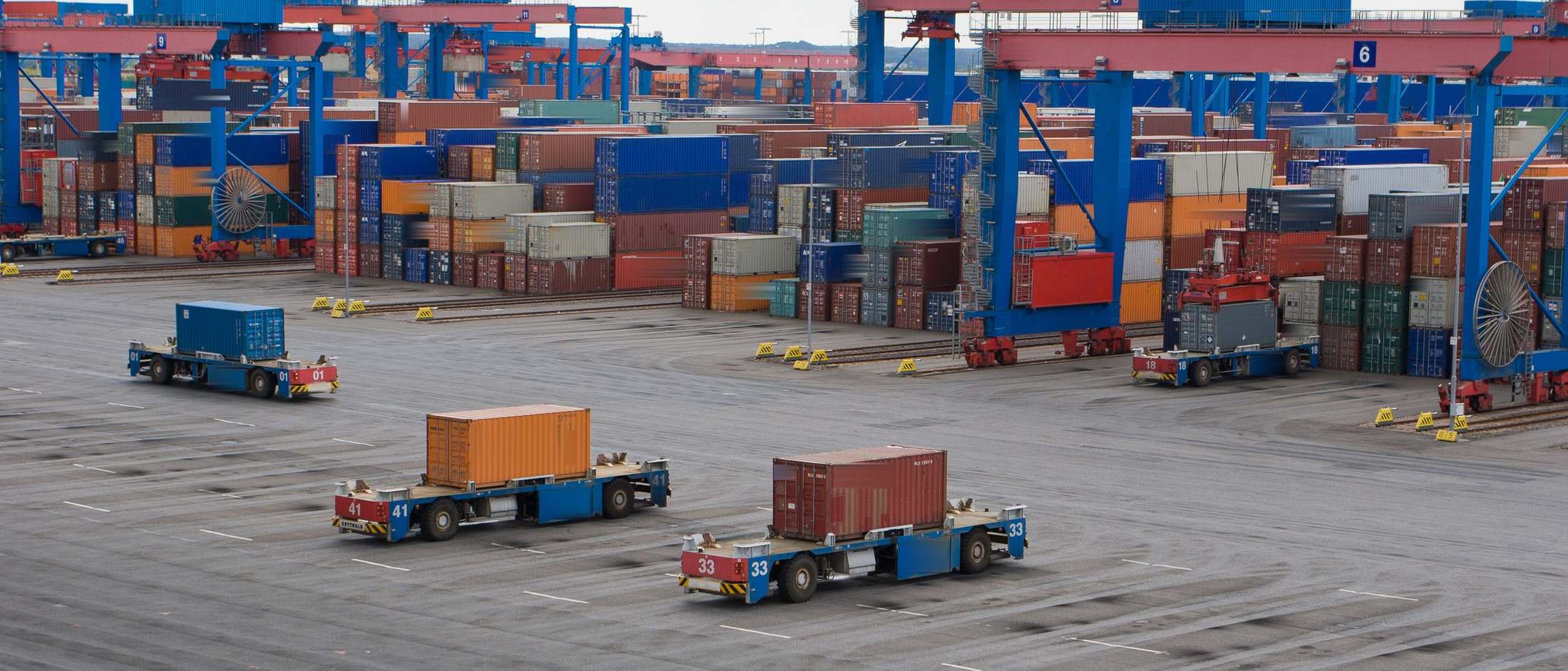 Automated guided vehicles moving containers at a terminal