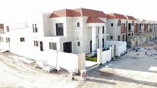 Completed houses at the Asad Babel Complex, with building work continuing on the units beyond